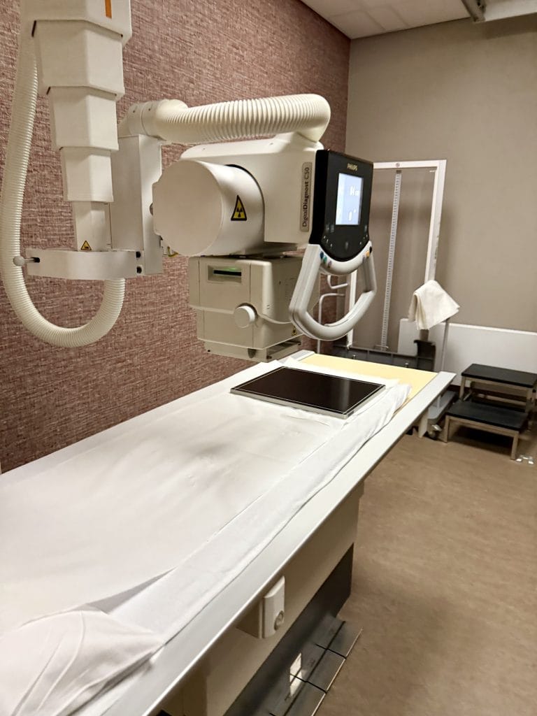 Philips DigitalDiagnost C50 X-ray tube head positioned over the exam table with detector panel